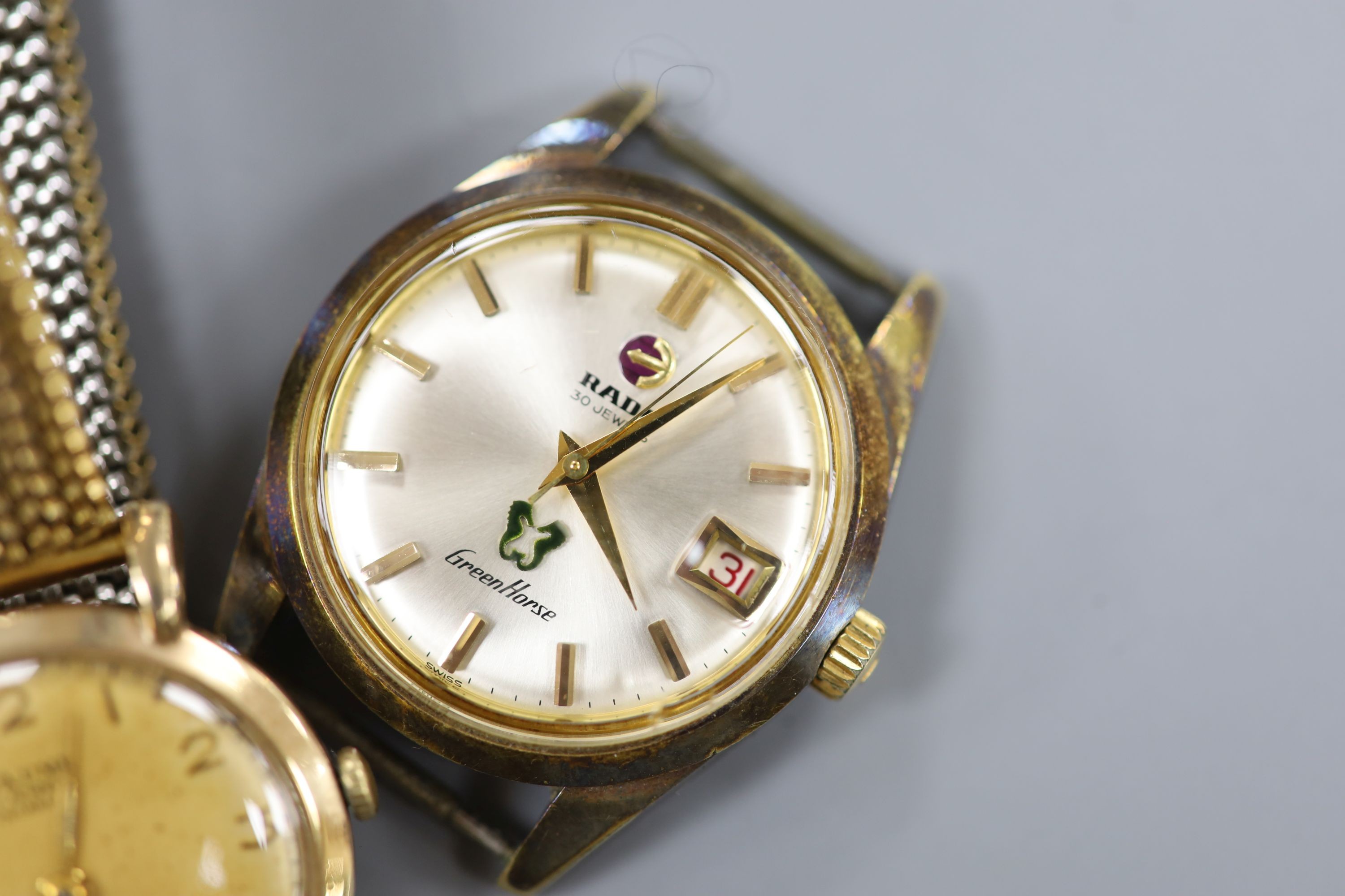 A gentleman's 9ct gold Baume manual wind wrist watch, on a gilt metal flexible strap and a gentleman's steel Rado Gren Horse wrist watch, no strap.